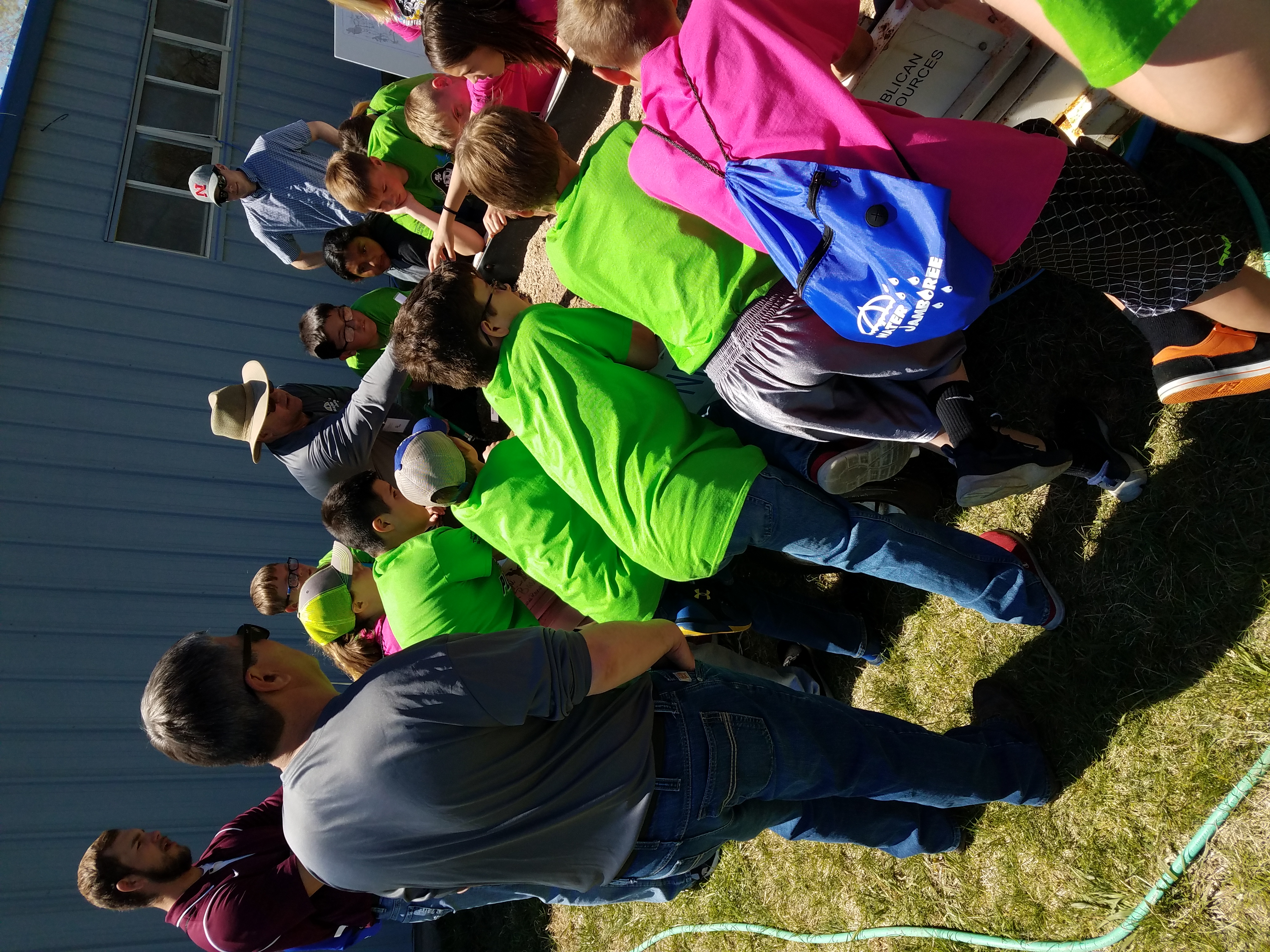 Extension Educator talking to kids around stream table