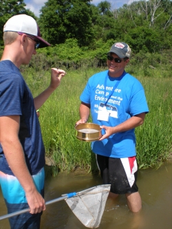 Student looking at what is found with net in river