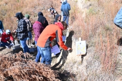 Student inspecting soil in the pit