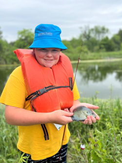 ACE camper with a nice size bluegill that he reeled in during the fishing session