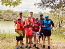 group of campers posed with two Lower Loup NRD staff members during a wetland ecology session (and the turtle they caught).