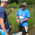 Student looking at what is found with net in river